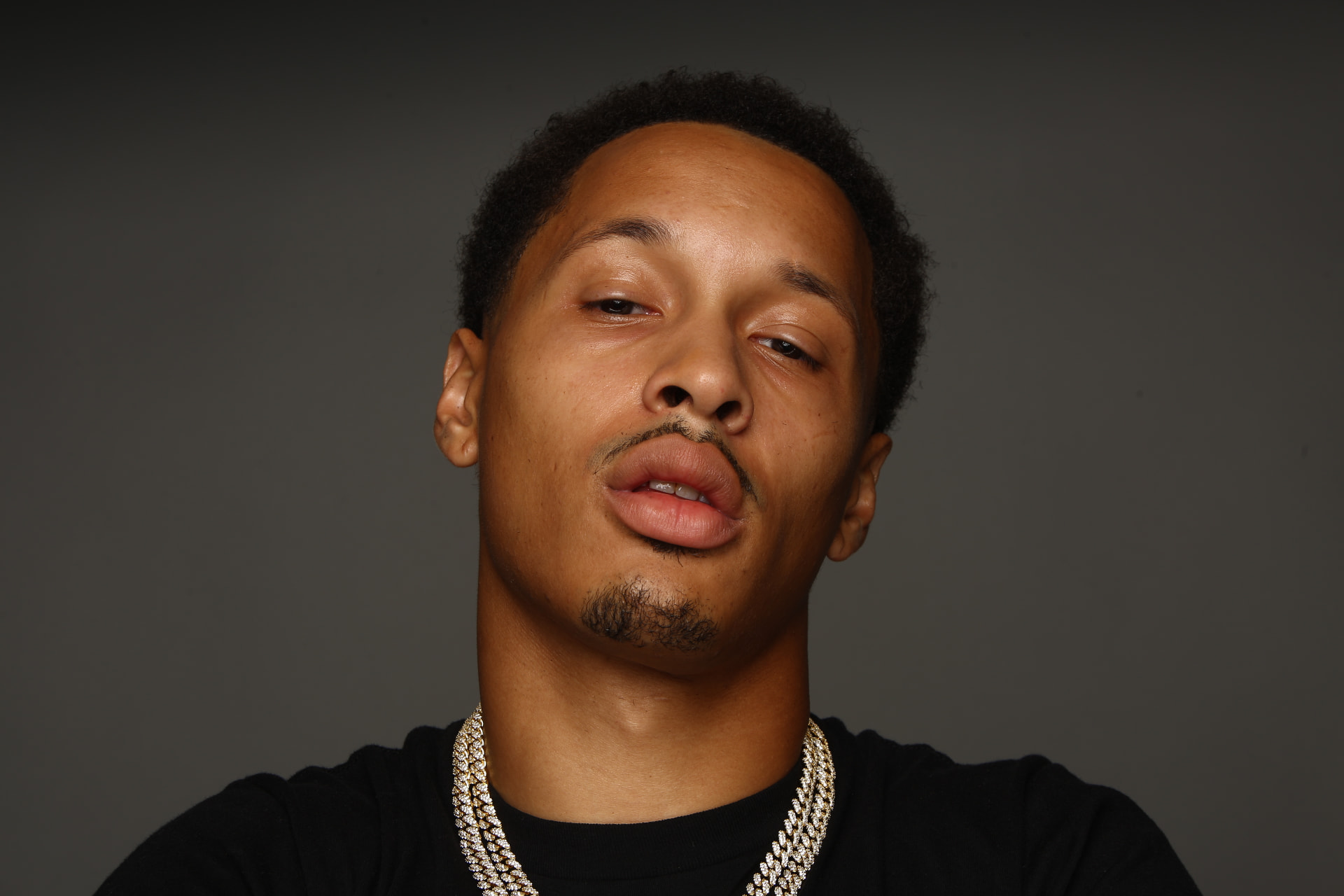 Worth Too Much in close-up portrait, diamond cuban chains, grey studio backdrop